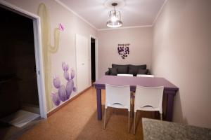 a dining room with a purple table and white chairs at Samay Departamentos in Salta +72 photos