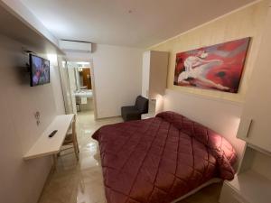 um quarto com uma cama e uma secretária num quarto em Bel Sole Guest House em Civitavecchia
