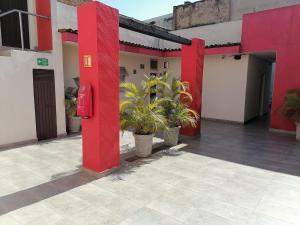 budynek z czerwonymi filarami i roślinami na dziedzińcu w obiekcie HOTEL MORELOS w mieście Guadalajara