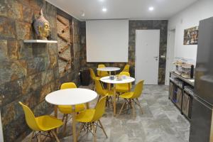 a dining room with tables and yellow chairs at River Dreams in Deltebre