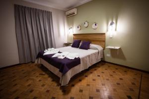 een slaapkamer met een groot bed en handdoeken bij Samay Departamentos in Salta