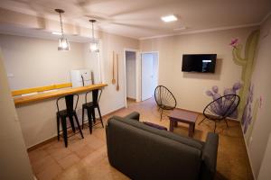 a living room with a couch and a bar with chairs at Samay Departamentos in Salta
