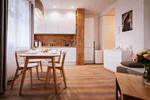 kuchnia i salon ze stołem i krzesłami w obiekcie Ottimo Apartamenty Floriana w Bydgoszczy