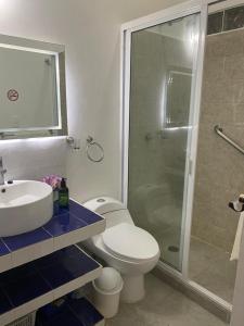 a bathroom with a shower and a toilet and a sink at FRIDA'S Home Sol A in Puerto Morelos