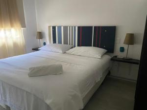 a bedroom with a large white bed with two pillows at FRIDA'S Home Sol A in Puerto Morelos