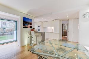 een woonkamer met een glazen tafel en een keuken bij Appartement Standing à Toulouse en centre ville in Toulouse