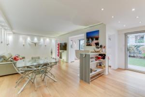 cocina y sala de estar con mesa de cristal y sillas en Appartement Standing à Toulouse en centre ville, en Toulouse