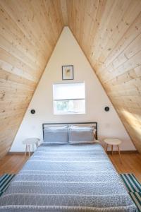 uma cama num quarto no sótão com tectos em madeira em Artbliss Hotel em Stevenson