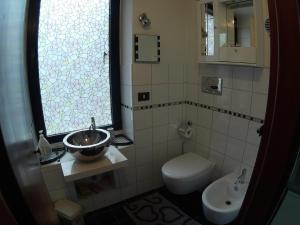 Un baño con lavabo, inodoro y ventana. en Central private flat by old town, shops, restaurants, en Bari