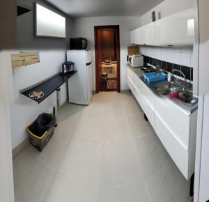 Una cocina con fregadero y refrigerador blanco. en Central private flat by old town, shops, restaurants, en Bari