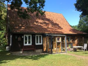 ein kleines schwarzes Haus mit rotem Dach in der Unterkunft Am Kräutergarten in Kirchlinteln