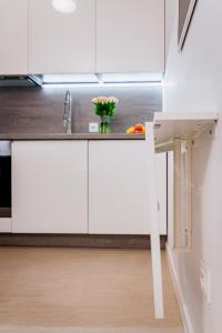 - une cuisine avec des placards blancs et un évier dans l'établissement Ottimo Apartamenty Dolina, à Bydgoszcz