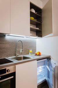 La cuisine est équipée d'un évier et d'un réfrigérateur ouvert. dans l'établissement Ottimo Apartamenty Dolina, à Bydgoszcz
