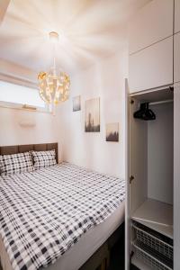 - une chambre avec un lit et un lustre dans l'établissement Ottimo Apartamenty Dolina, à Bydgoszcz