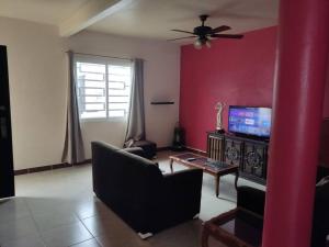 a living room with a couch and a flat screen tv at Cómoda casa de descanso in Santa Cruz Xoxocotlán