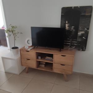 a flat screen tv on a wooden entertainment center at Bauhaus departamento centro in Córdoba