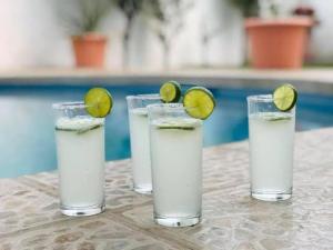 tres vasos de agua con una lima en una mesa en Casa con amplio jardín y alberca, en Tenango de Arista