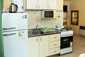 uma cozinha com um frigorífico branco e um lavatório em Lo de Hilda em Villa Elisa
