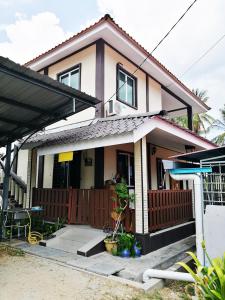 a house with a fence in front of it at Haji Hassan Guesthouse in Pantai Cenang