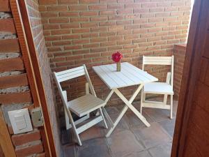 a table and two chairs sitting next to a brick wall at CABAÑAS DE LAS MARIPOSAS in Valle de Bravo +9 photos