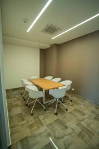 a conference room with a wooden table and white chairs at Suite de lujo Distrito 90 in Barranquilla