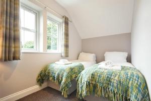 two twin beds in a room with a window at Russet in Lucker