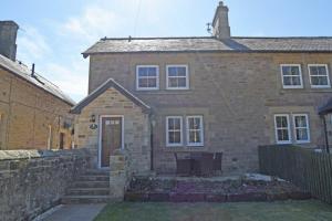 a brick house with a door and a stone wall at Russet in Lucker