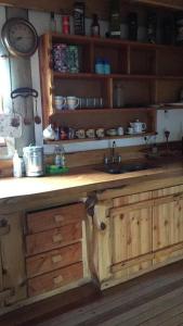 a kitchen with a wooden counter with a sink at La Joaquina, Casa de montaña. in El Chalten