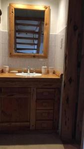 y baño con lavabo y espejo. en La Joaquina, Casa de montaña. en El Chaltén