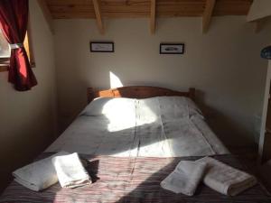 1 dormitorio con 1 cama con 2 almohadas en La Joaquina, Casa de montaña. en El Chalten