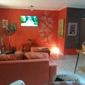 sala de estar con sofá y TV en la pared en ARTE Y VINO en Maipú