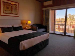a hotel room with a bed and a balcony at Desert Cave Hotel in Coober Pedy