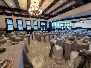 un gran salón de banquetes con mesas y sillas blancas en Yogo Inn, en Lewistown