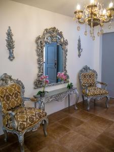 a room with two chairs and a mirror at The Royalty Inn ApartmentHotel #1 in Guayaquil