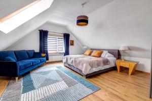um quarto com uma cama e um sofá azul em Rentimi - Willa Bella Kościelna 28 em Muszyna