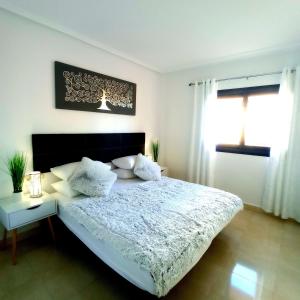 a bedroom with a large bed with white sheets and pillows at Luxury large 2 bedroom Apartment short walk to Villamartin Plaza in Villamartin