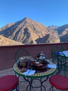 Gite Tizi Mizik في إمليل: طاولة عليها طعام مع جبل في الخلف