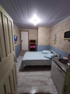 Kitnet Barra de Ibiraquera في بارا دي إيبيراكويرا: غرفة نوم بسرير ومغسلة في غرفة