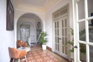 a hallway with a door and chairs in a house at AmazINN Places Rooftop and Jacuzzi VI in Panama City