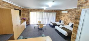 a hotel room with two beds and a table at Golf Club Motor Inn Wingham in Wingham
