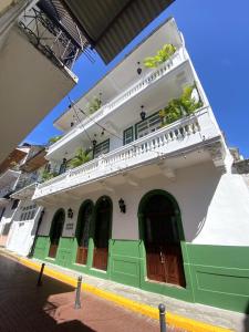 biało-zielony budynek z zielonymi drzwiami i oknami w obiekcie AmazINN Places Rooftop and Jacuzzi V w Panamie