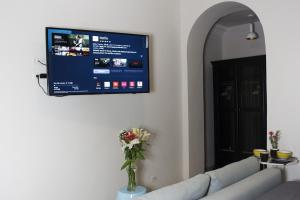 a living room with a couch and a tv on the wall at AmazINN Places Rooftop and Jacuzzi II in Panama City