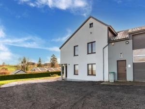 una casa blanca con garaje en una entrada en Cozy holiday home for 6 people in Léglise in the Ardennes, en Léglise