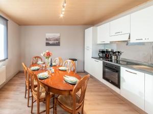 cocina y comedor con mesa de madera y sillas en Cozy holiday home for 6 people in Léglise in the Ardennes, en Léglise