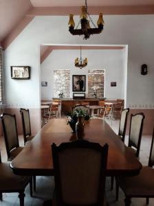 une salle à manger avec une grande table et des chaises en bois dans l'établissement Los Abuelos Hostal Huajuapan, à Huajuapan de León