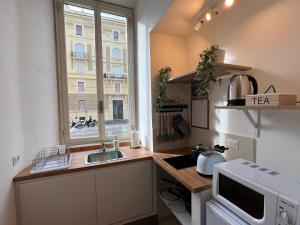 eine kleine Küche mit einem Waschbecken und einem Fenster in der Unterkunft La tua casa nel centro di Roma in Rom