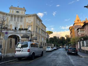a white van parked on a street in front of a building at La tua casa nel centro di Roma in Rome