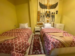 a room with two beds in a room at Bella Casa Pyramids Inn in Cairo