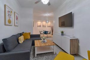 a living room with a couch and a tv at Dom. Rep. Exclusive 2 bed Apt. Evaristo Morales in Santo Domingo