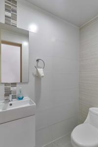 a white bathroom with a toilet and a sink at Dom. Rep. Exclusive 2 bed Apt. Evaristo Morales in Santo Domingo